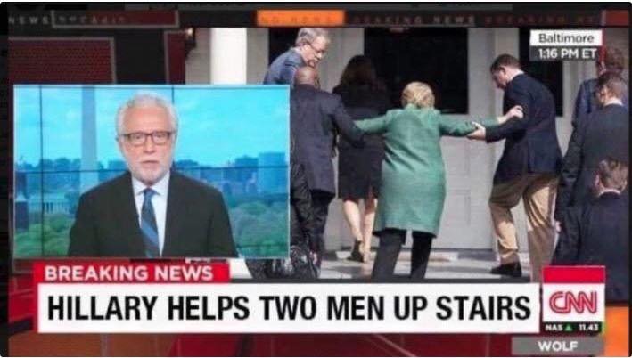 Hillary helping two men up stairs